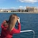 A woman on a boat taking pictures of the Cathedral of Santa Maria of Palma in Mallorca, Spain